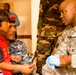 Army Captain Engages with Iraqi Policeman and Boy During Medical Outreach in Kut
