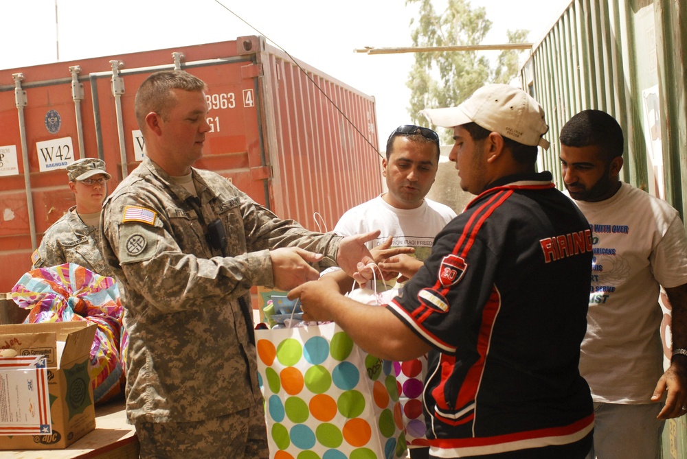 U.S. Soldier Distributes Toys and Clothing to Iraqi Worker