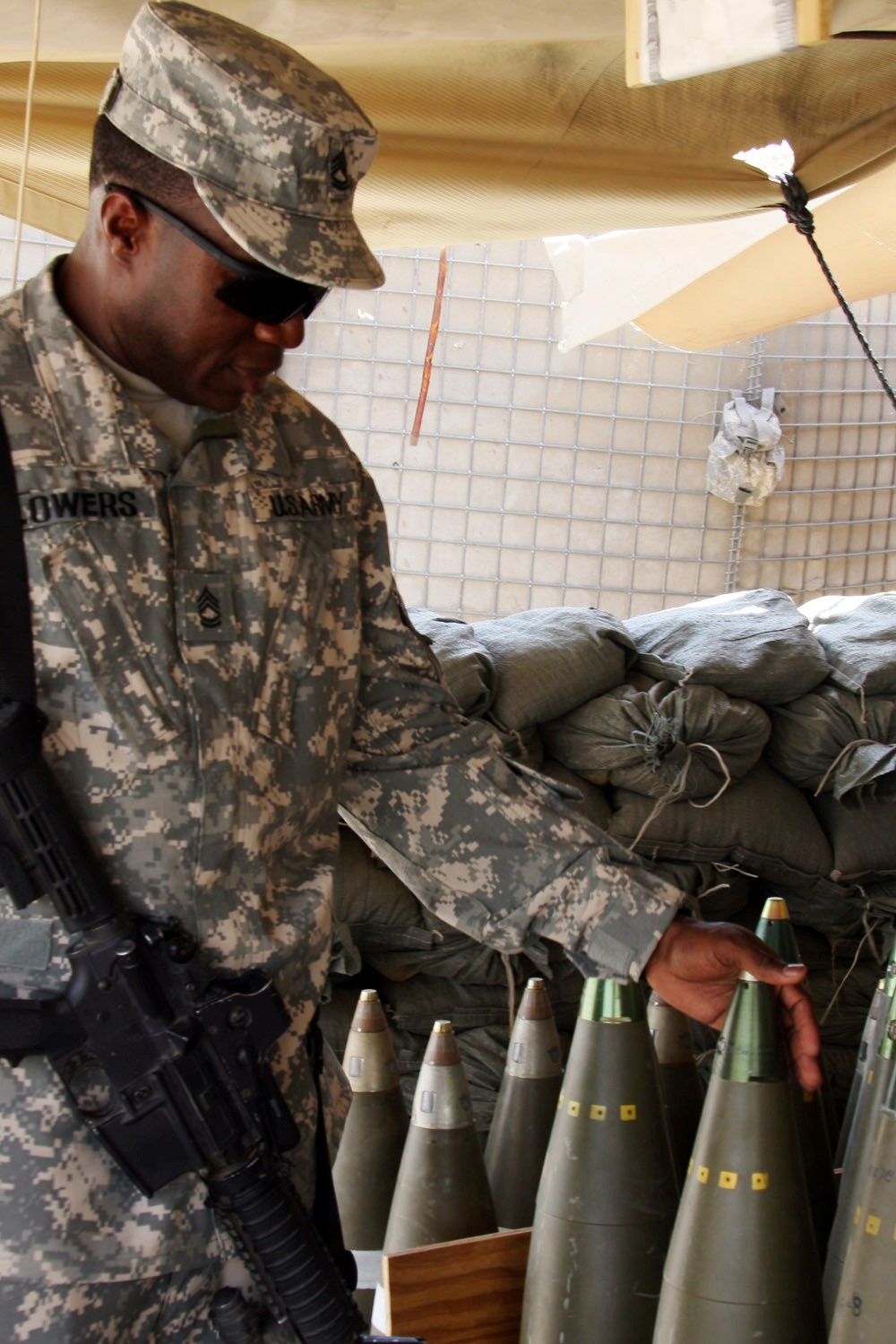 Army Sergeant Inspects Howitzer Projectile in Iraq