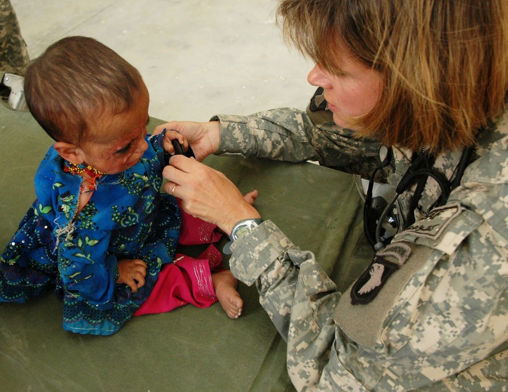 U.S. Navy Officer Provides Medical Care to Afghan Child During Outreach Event