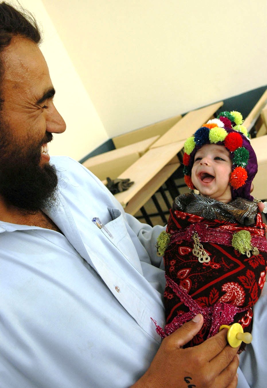 Afghan Father Shares Joyful Moment with Son at Medical Outreach Event