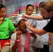 Air Force Airman Assists Patient with Glasses During Medical Mission in Philippines
