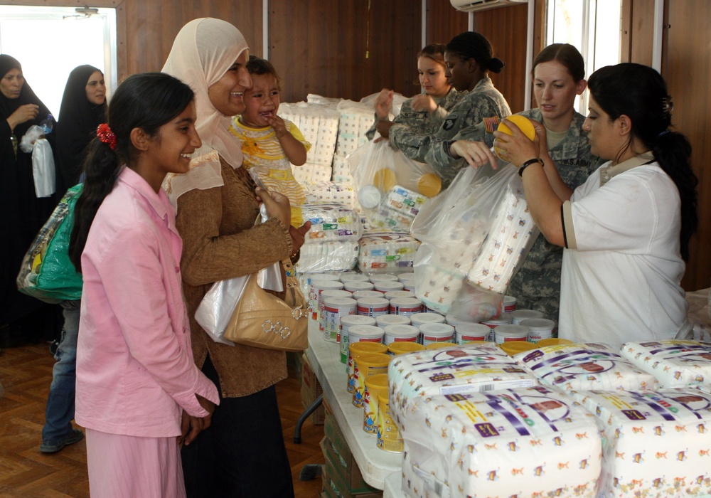Soldiers and Advisor Provide Aid to Waiting Mothers in Iraq