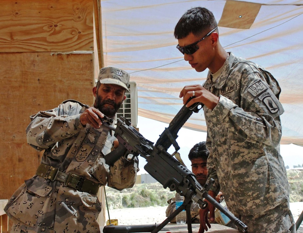 U.S. Soldier Trains Afghan Border Patrol Officer on Weapon Reassembly