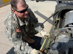 Army Warrant Officer Inspects Apache Helicopter Before Mission in Baghdad