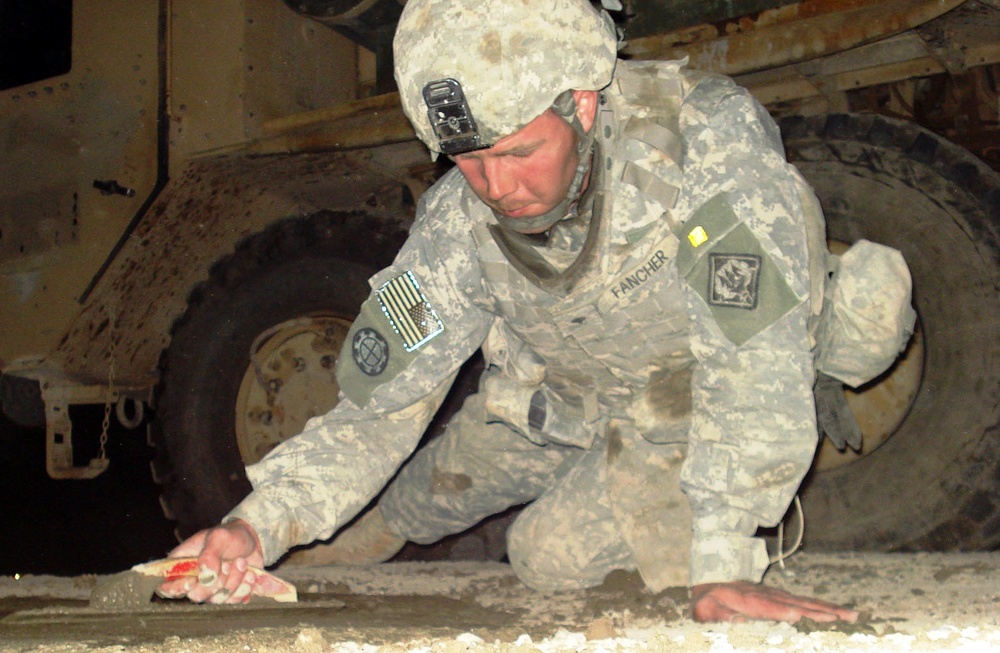 Army Spc. Repairs Roadway Crater in Baghdad