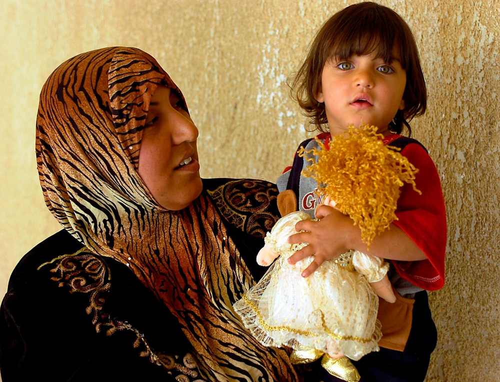 Iraqi Child Clutches New Doll Received from U.S. and Iraqi Soldiers