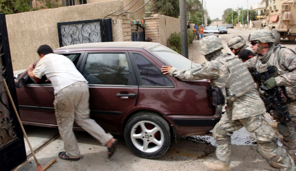 Soldiers Assist Iraqi Resident in Baghdad Neighborhood