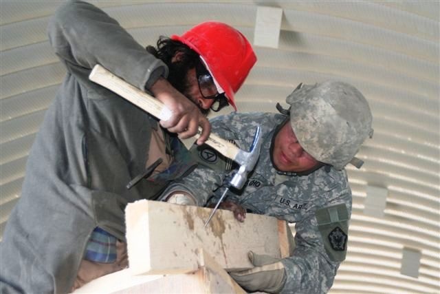 Army Spc. Guides Afghan Man During Skilled-Labor Workshop in Afghanistan