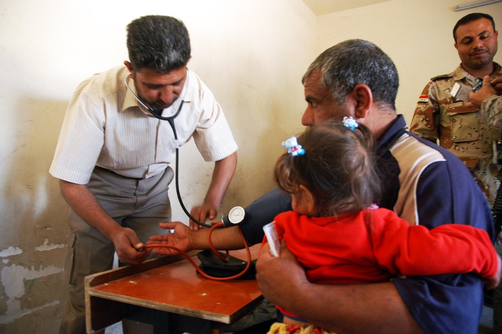 Iraqi Doctor Checks Patient's Blood Pressure in Bata Village