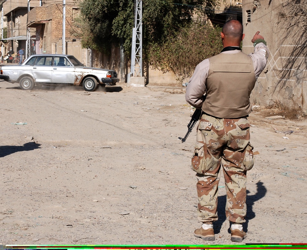 Sons of Iraq Member Directs Traffic at Baghdad Checkpoint