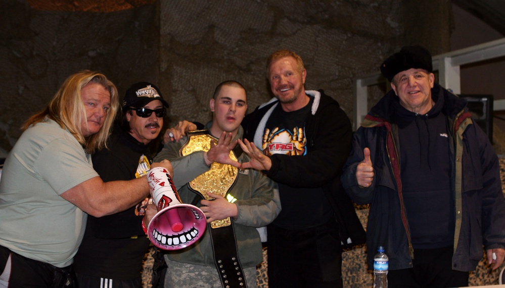 Army Soldier Poses with Wrestling Legends at Bagram Air Base