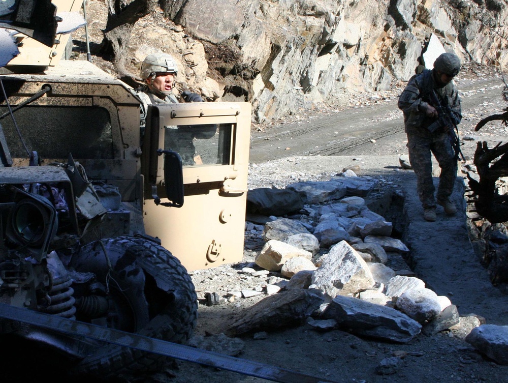 Army Officer Assesses Damaged Vehicle in Afghanistan
