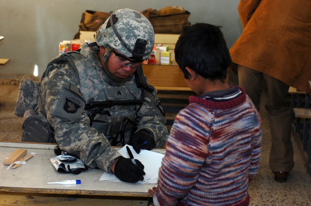 Army Medic Provides Health Assessment for Iraqi Boy During Medical Operation