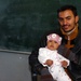 Iraqi Father Holds Infant Before Medical Exam in Baghdad