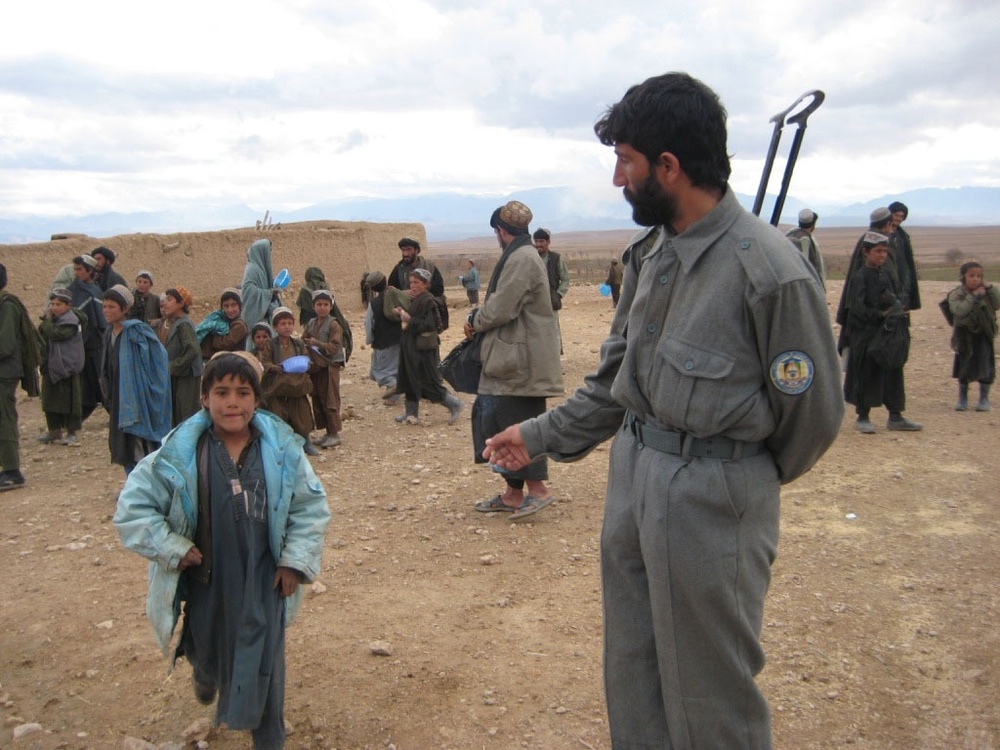 Afghan Policeman Greets Boy During Village Visit in Oruzgan Province