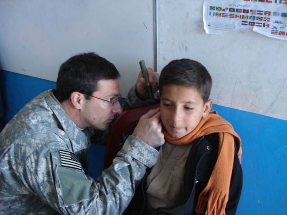 Coalition Forces Soldier Examines Afghan Boy at Orphanage in Kandahar