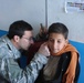 Coalition Forces Soldier Examines Afghan Boy at Orphanage in Kandahar