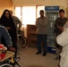 Oliver North Visits Iraqi Child Receiving Wheelchair at Radwaniyah Palace Complex