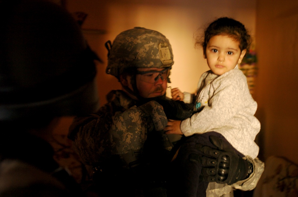 U.S. Soldier Comforts Child During Baghdad Clearing Operation