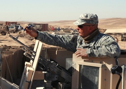Soldier Cleans Weapon During Patrol in Afghanistan