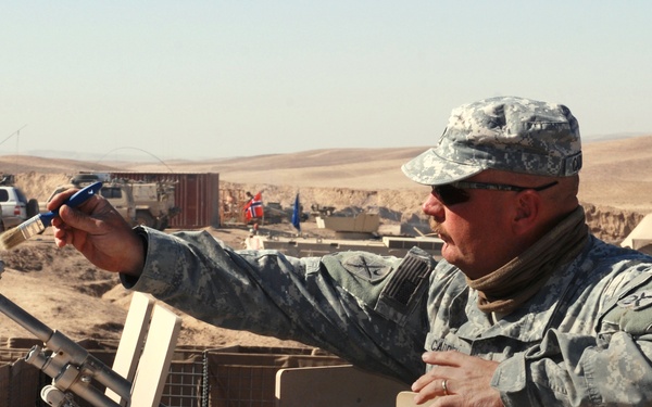 Soldier Cleans Weapon During Patrol in Afghanistan