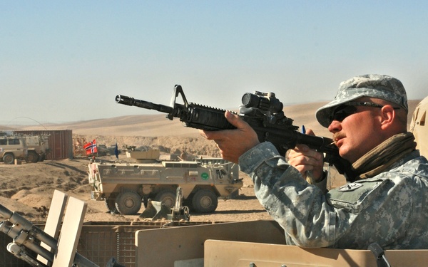 Soldier Cleans Rifle During Patrol in Afghanistan