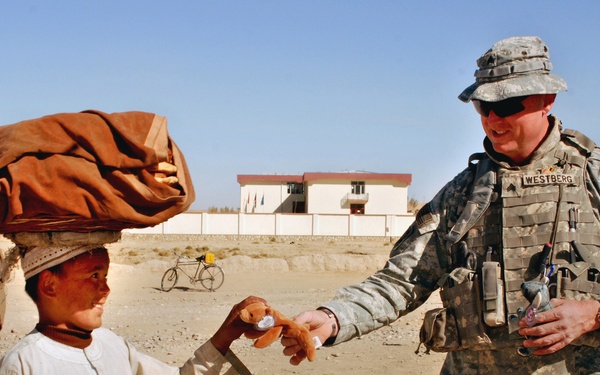 U.S. Soldier Gives Toy to Afghan Boy Outside Police Station