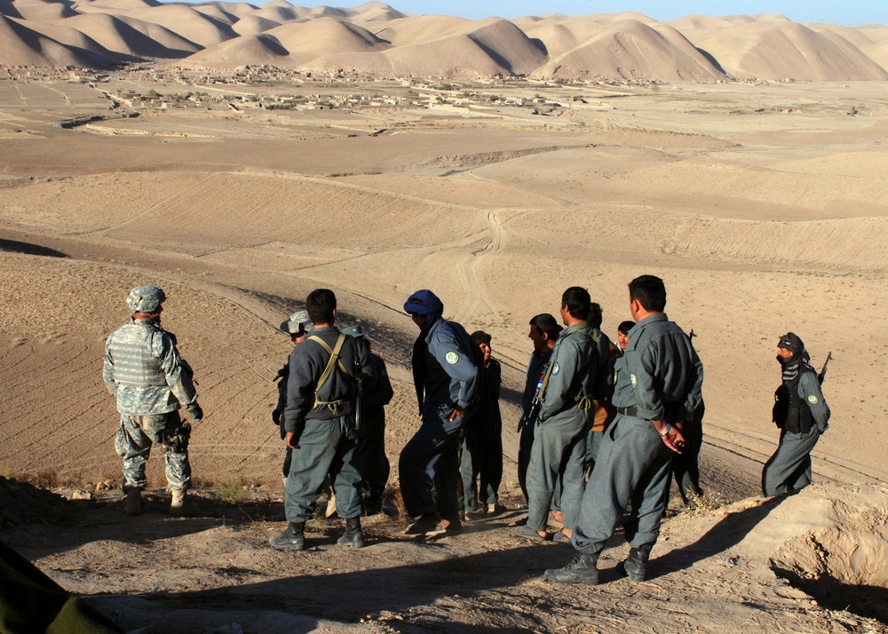 Army Captain Receives Security Update from Afghan Police During Operation