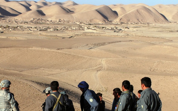 Army Captain Receives Security Update from Afghan Police During Operation