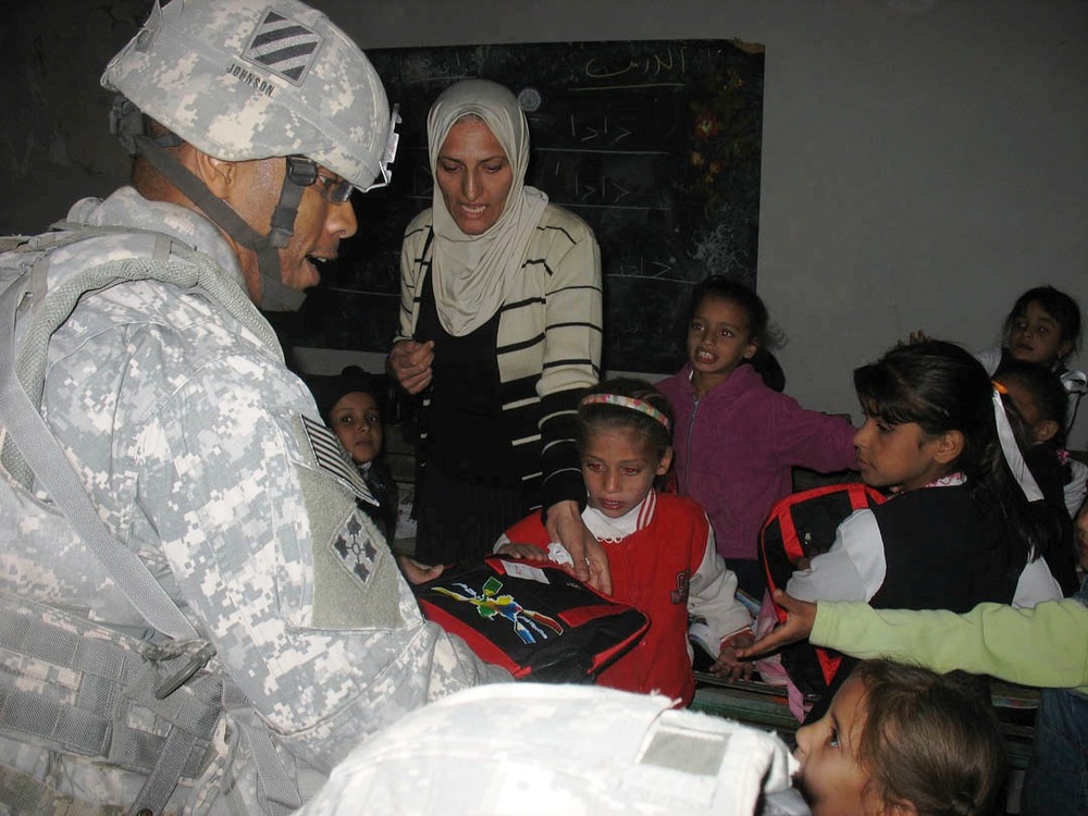 Army Officer Distributes Backpacks to Iraqi Students