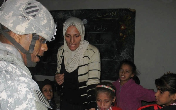 Army Officer Distributes Backpacks to Iraqi Students