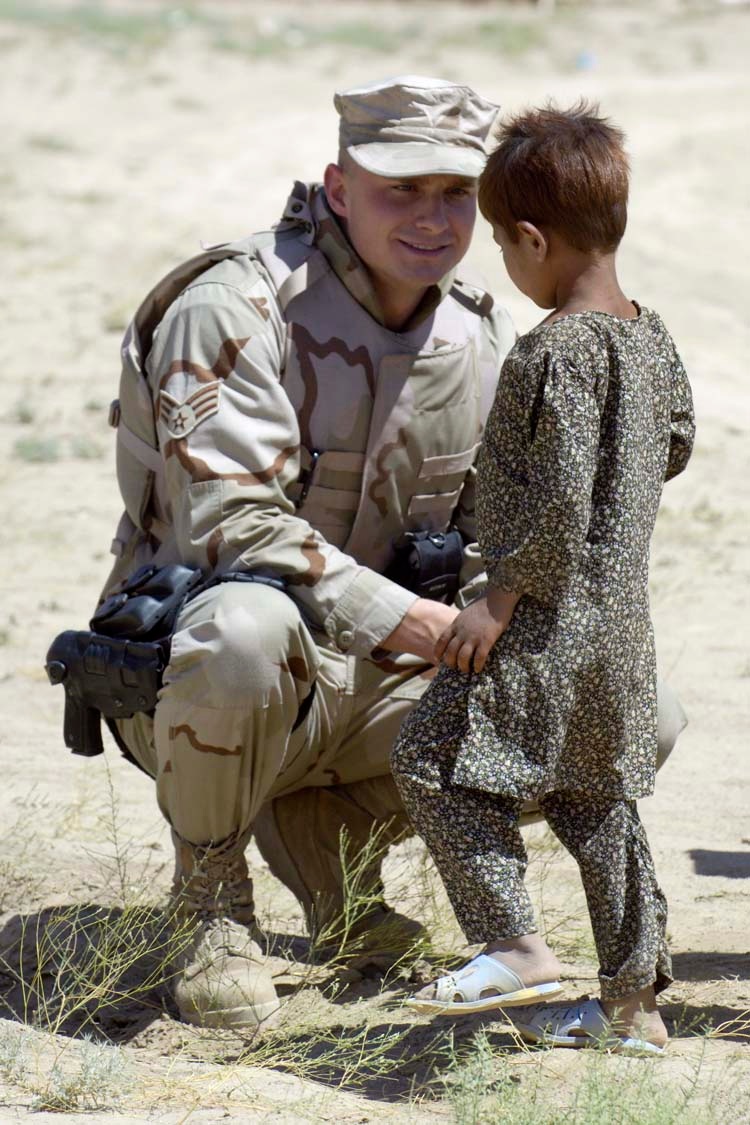 Air Force Airman Greets Afghan Child at Refugee Camp