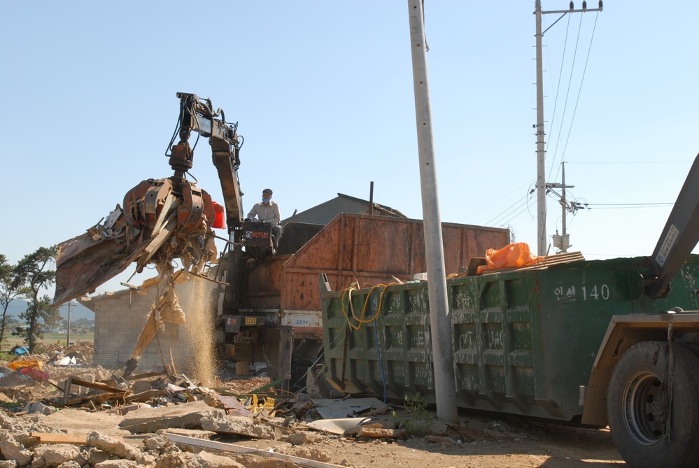 Clearing the Way: Heavy Equipment Hauls Debris at Camp Humphreys Construction Site