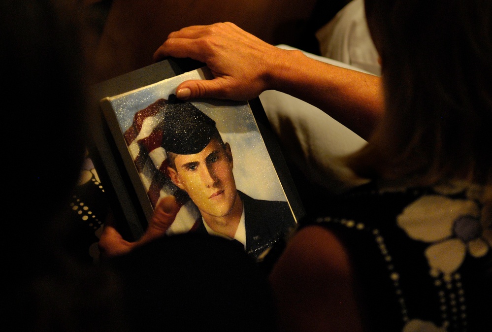 Mother Holds Painting of Son at Fallen Soldiers Exhibit Closing
