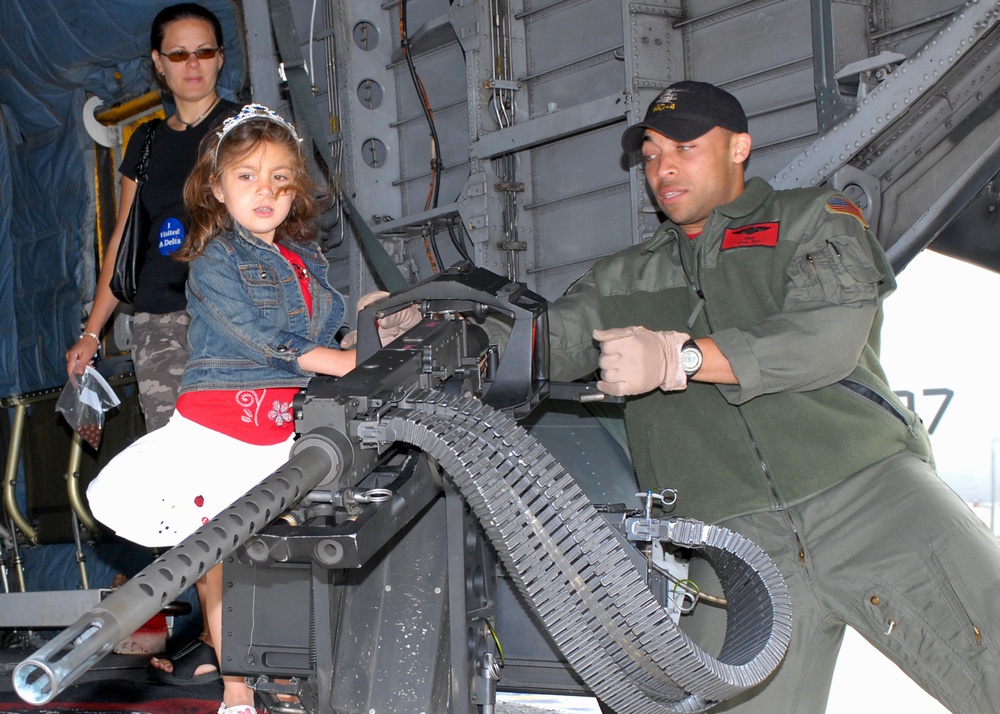 Navy Petty Officer Simulates Firing Machine Gun from Helicopter at Air Show