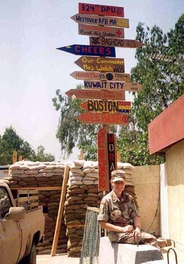 Army Officer Maj. Deborah Gilmore Poses with Directional Sign in Saudi Arabia During 1991 Gulf War