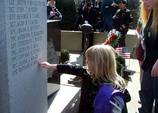 Solemn Remembrance: Daughter Touches Memorial for 14th Quartermaster Detachment