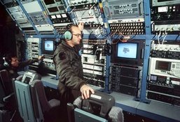 Air Force Crew Member Adjusts Transmission During EC-130E Training Mission