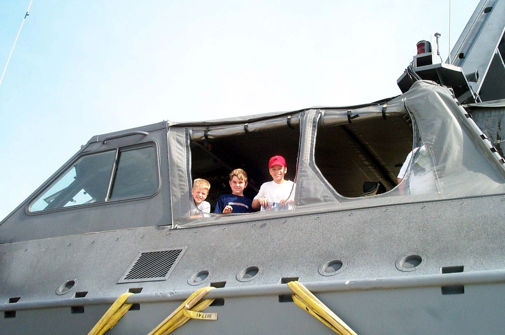 Children Peek at Parents from Military Watercraft at Air Force Open House