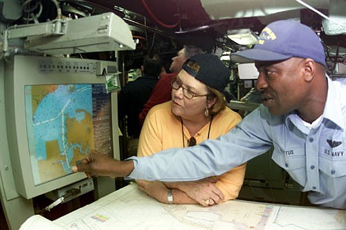 Businesswoman Learns About Navigational Aids from Sailor
