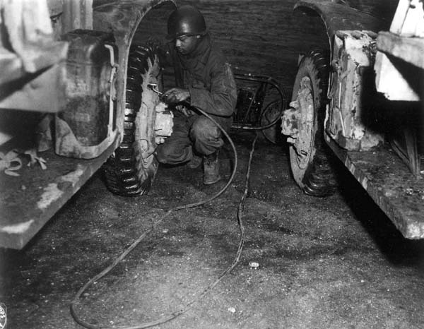Truck Driver Maintains Tire on Red Ball Express During WWII