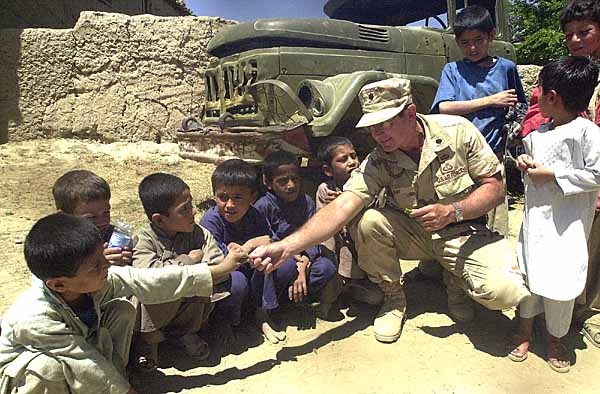 U.S. Army Officer Distributes Candy to Afghan Children at School Near Bagram Air Base