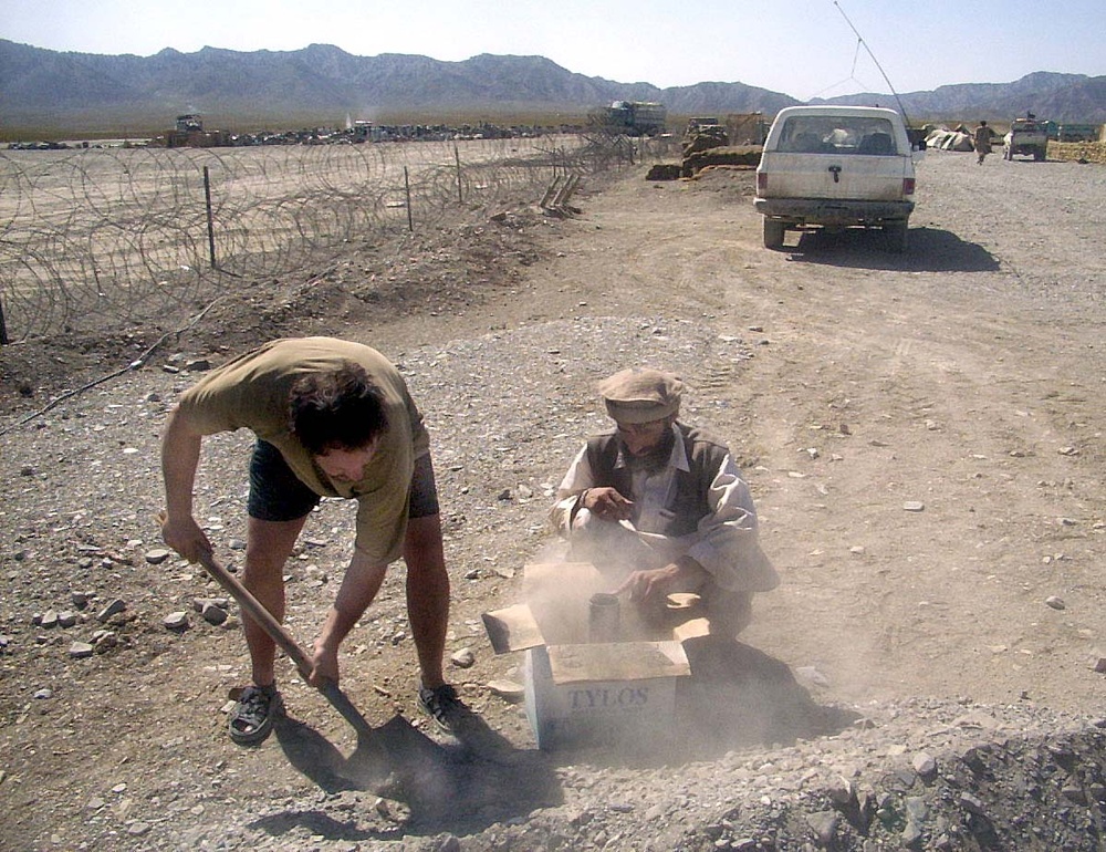 Army Engineer Collaborates with Local Worker on Road Project in Afghanistan