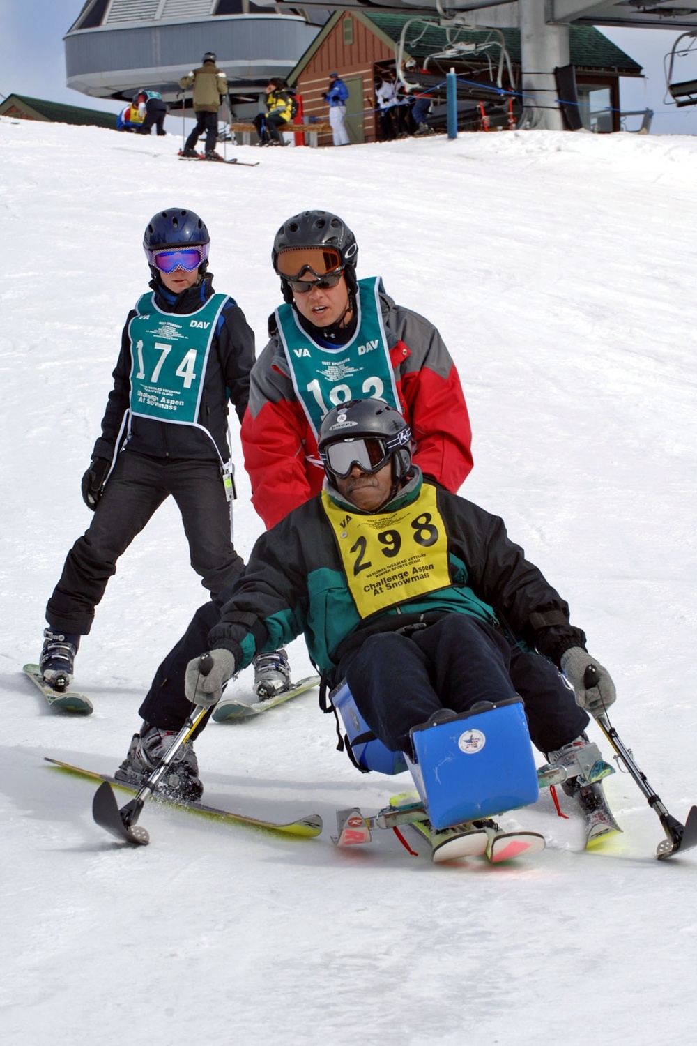 Disabled Veteran Skis with Volunteer Instructors at Winter Sports Clinic