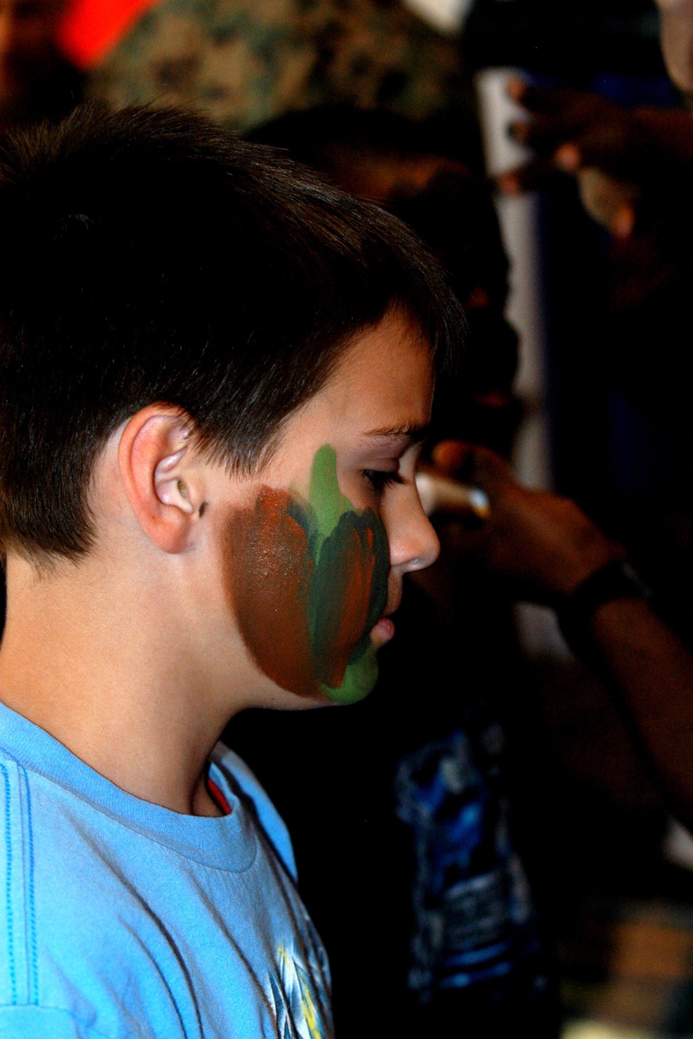 Young Student Learns Camouflage Face Painting at Marine Corps Exhibit