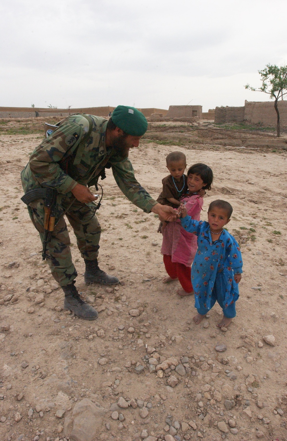 Afghan Soldier Shares Gum with Local Children During Patrol
