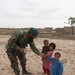 Afghan Soldier Shares Gum with Local Children During Patrol
