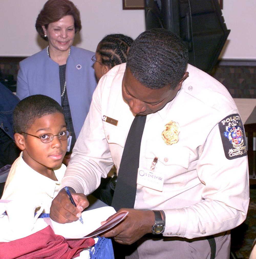Police Chief Autographs Program for Student at MLK Breakfast