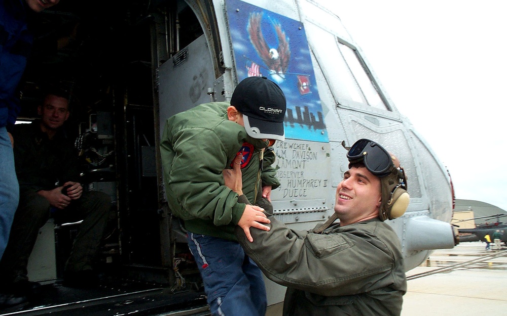 Marine Reservist Helps Young Boy Disembark Helicopter at Air Show